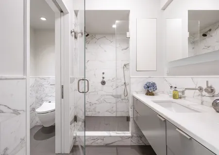 a bathroom with a granite countertop sink a toilet and shower