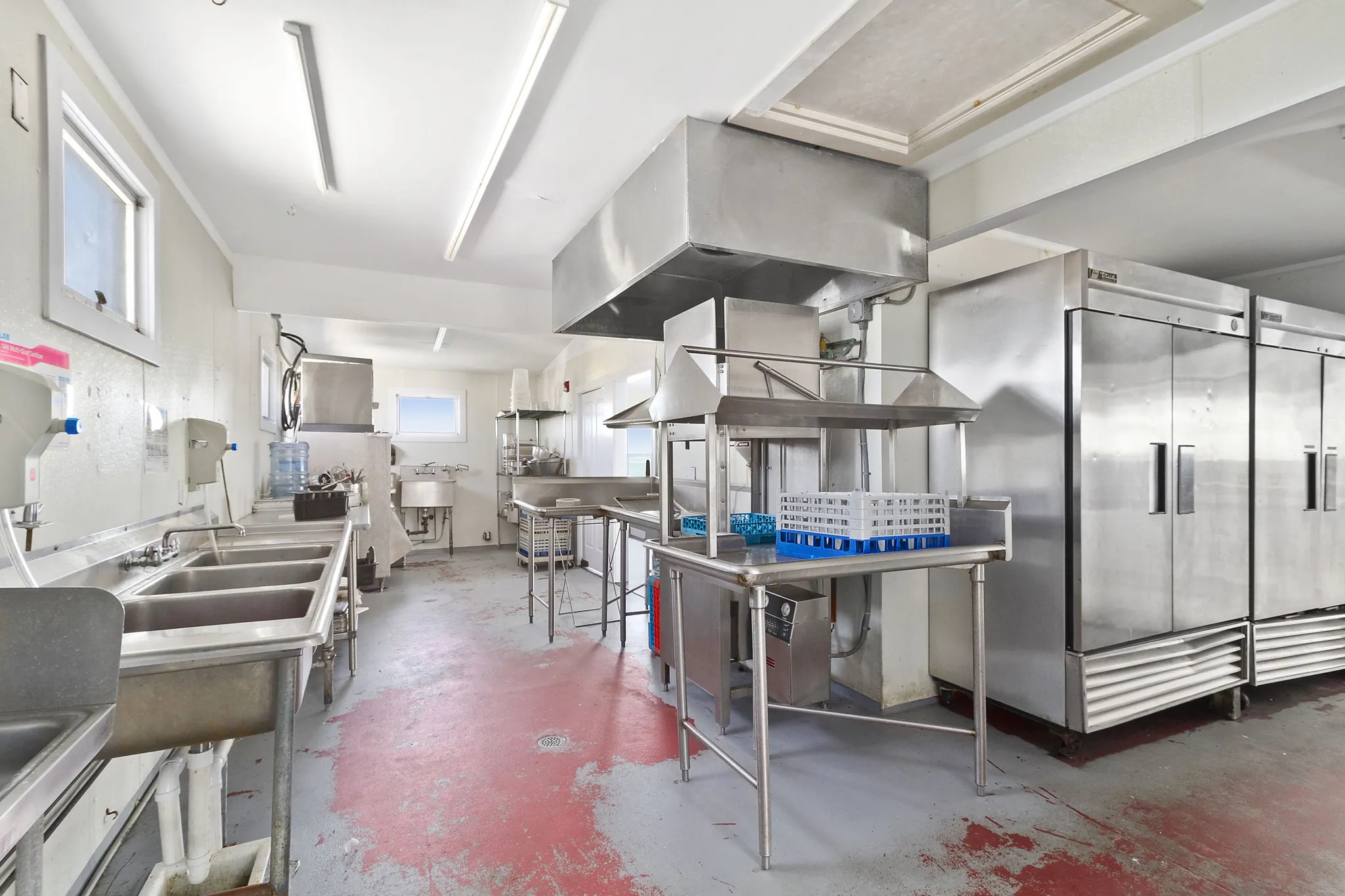 363 Beach Road Hampton Bays, NY 11959 - Photo 23 of 27 a kitchen with stainless steel appliances a stove a chimney a sink and cabinets