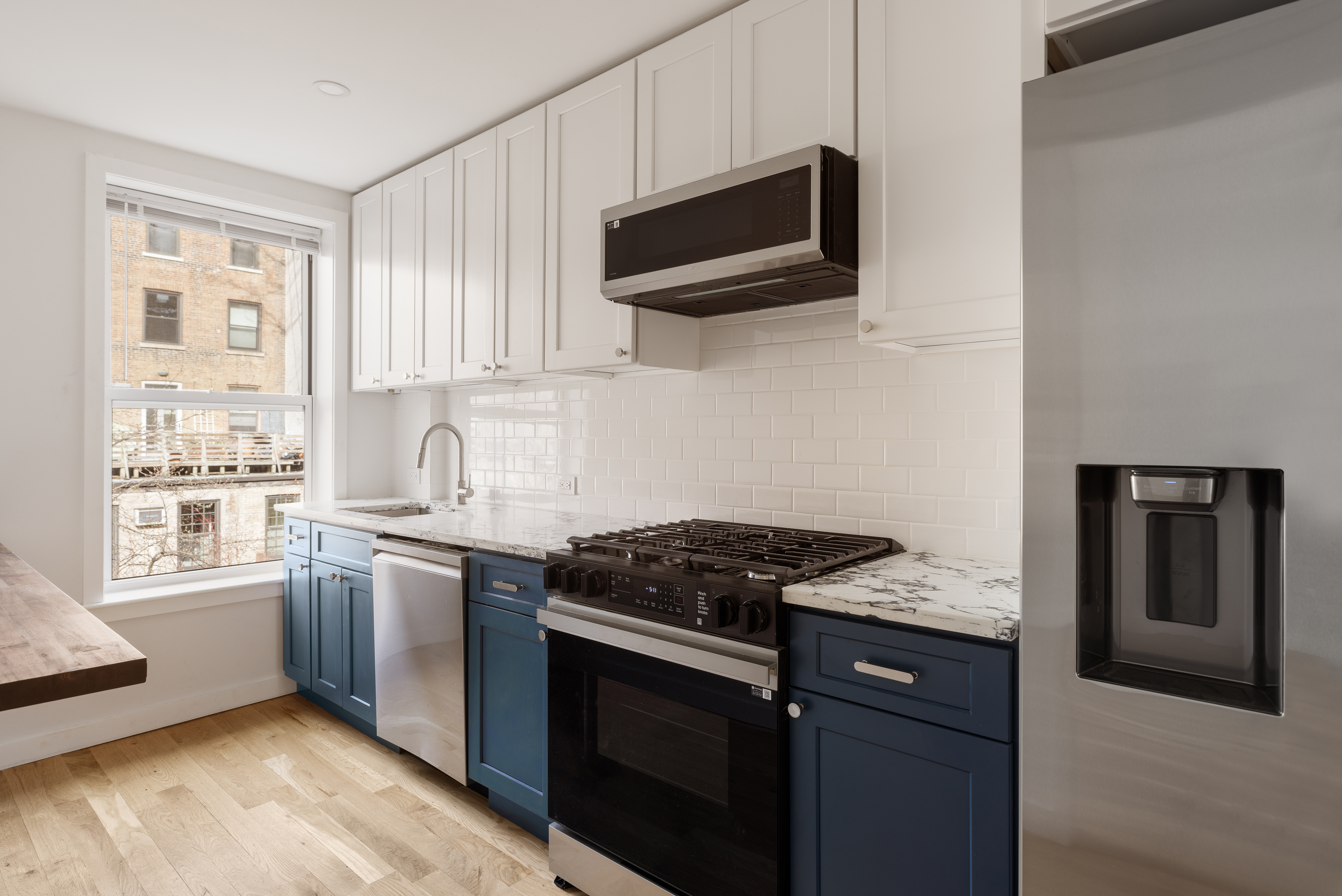 147 Atlantic Avenue, Unit 2 Brooklyn, NY 11201 - Photo 3 of 8 a kitchen with stainless steel appliances granite countertop a stove a sink and a microwave