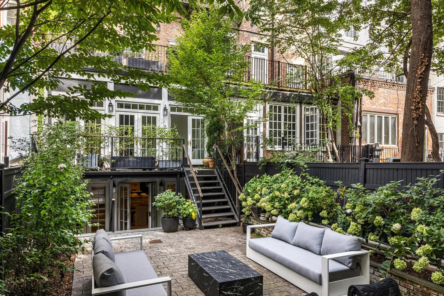 a view of a patio with couches table and chairs and potted plants