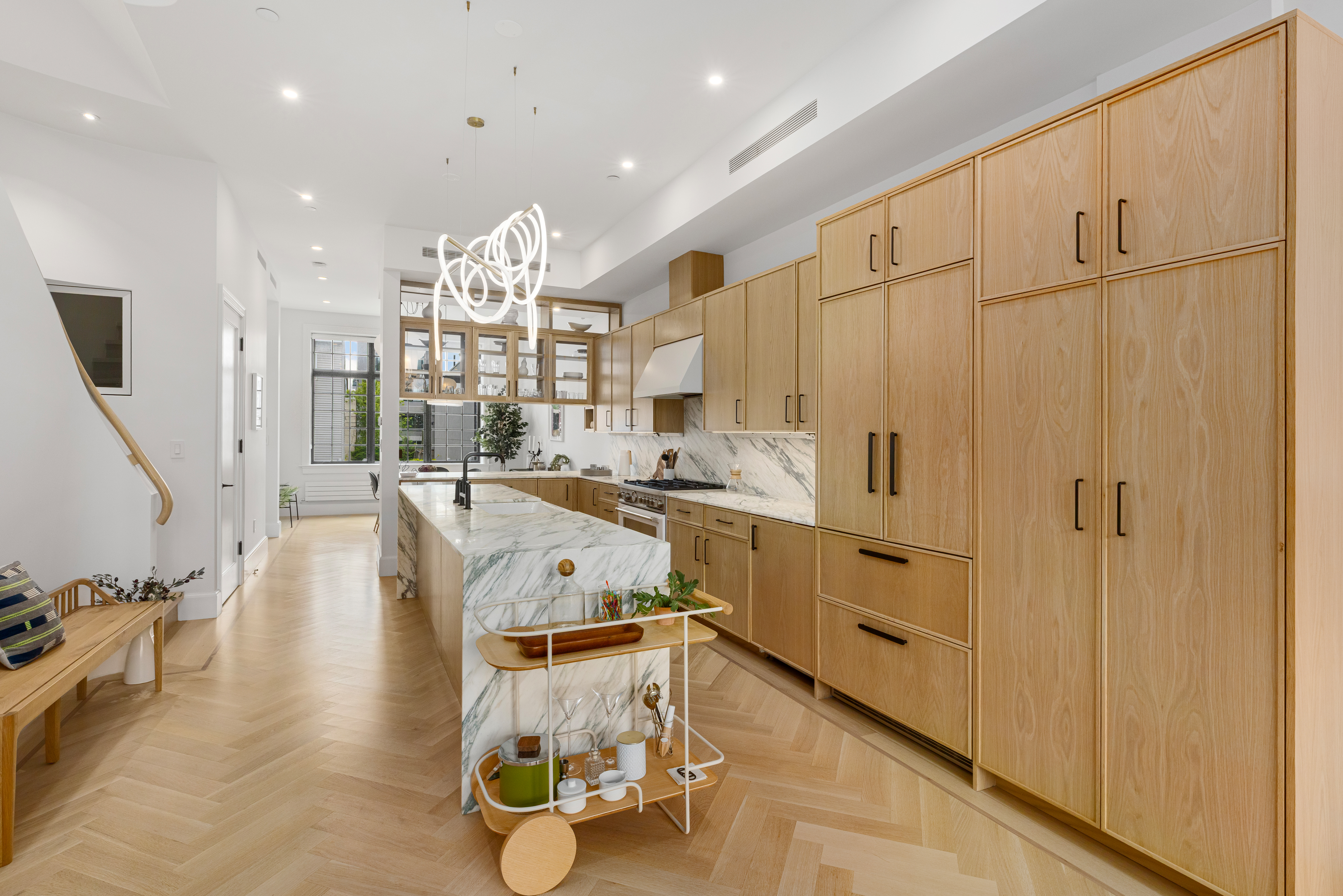 179 Devoe Street Brooklyn, NY 11211 - Photo 5 of 20 a view of a kitchen with kitchen island stainless steel appliances wooden floor and living room view