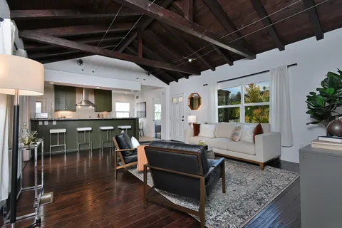 a dining hall with granite countertop a stove a sink a dining table and chairs with wooden floor