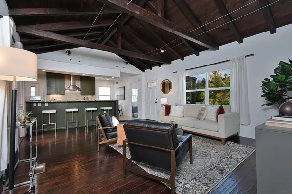 a dining hall with granite countertop a stove a sink a dining table and chairs with wooden floor