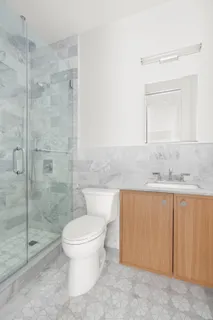 a bathroom with a granite countertop sink a toilet and shower