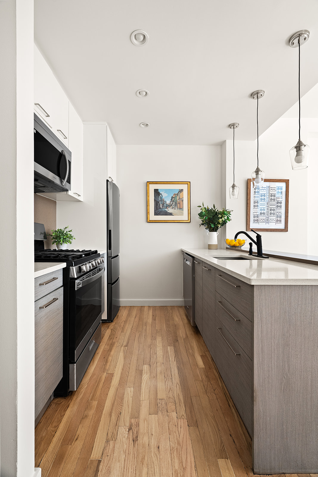 333 East 109th Street, Unit 7A Manhattan, NY 10029 - Photo 4 of 11 a kitchen with stainless steel appliances a stove a sink a refrigerator wooden floor and cabinets