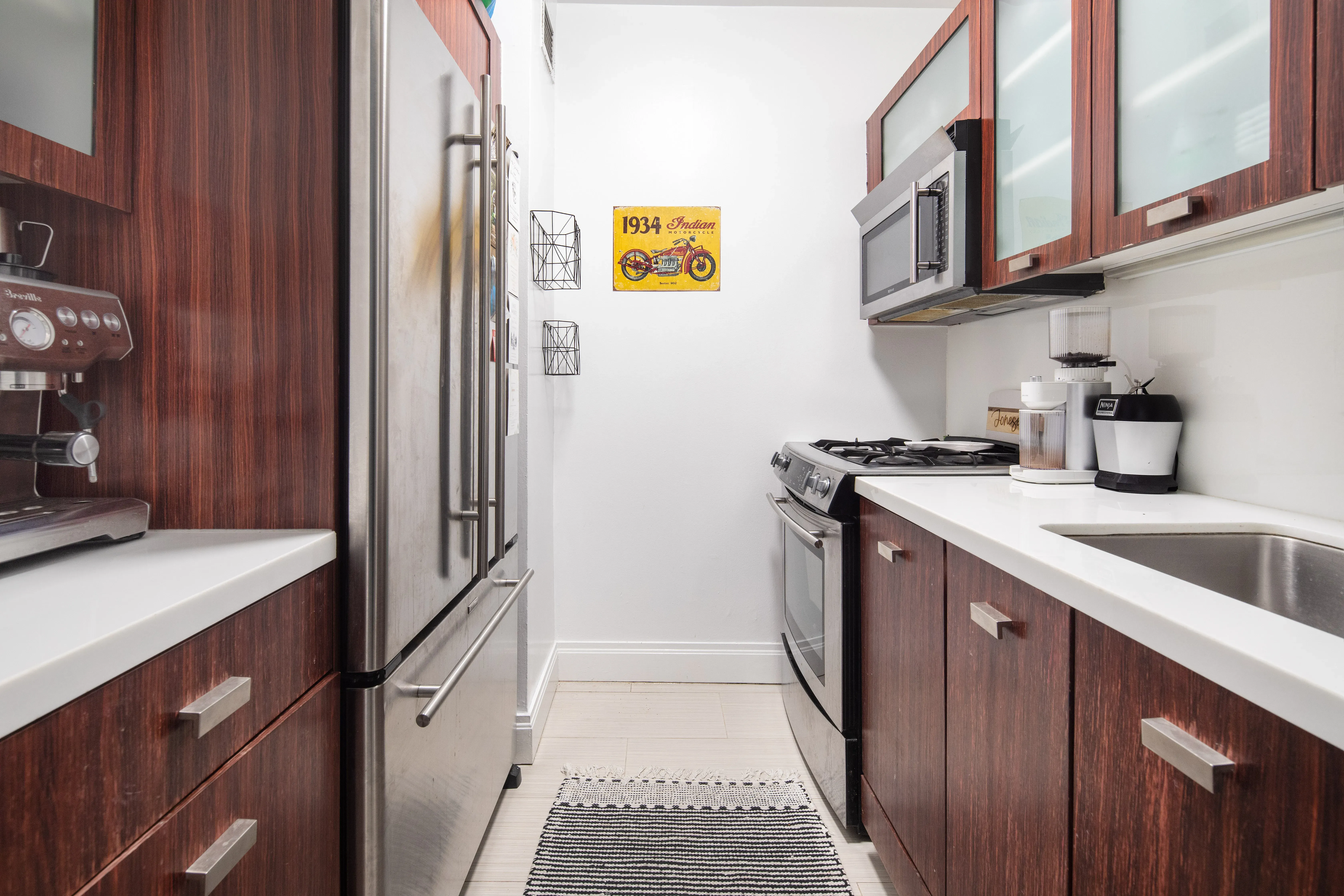 212 East 47th Street, Unit 21D Manhattan, NY 10017 - Photo 6 of 16 a kitchen with stainless steel appliances granite countertop a sink and cabinets