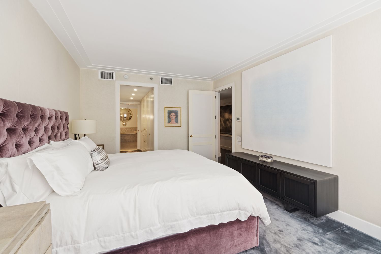 a bedroom with a bed and a refrigerator