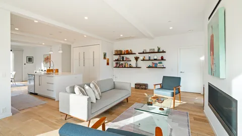 a living room with furniture and kitchen view