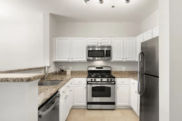 a kitchen with a sink stove and white stainless steel appliances