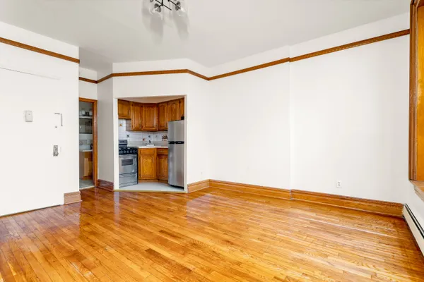a view of a room with wooden floor and a ceiling fan