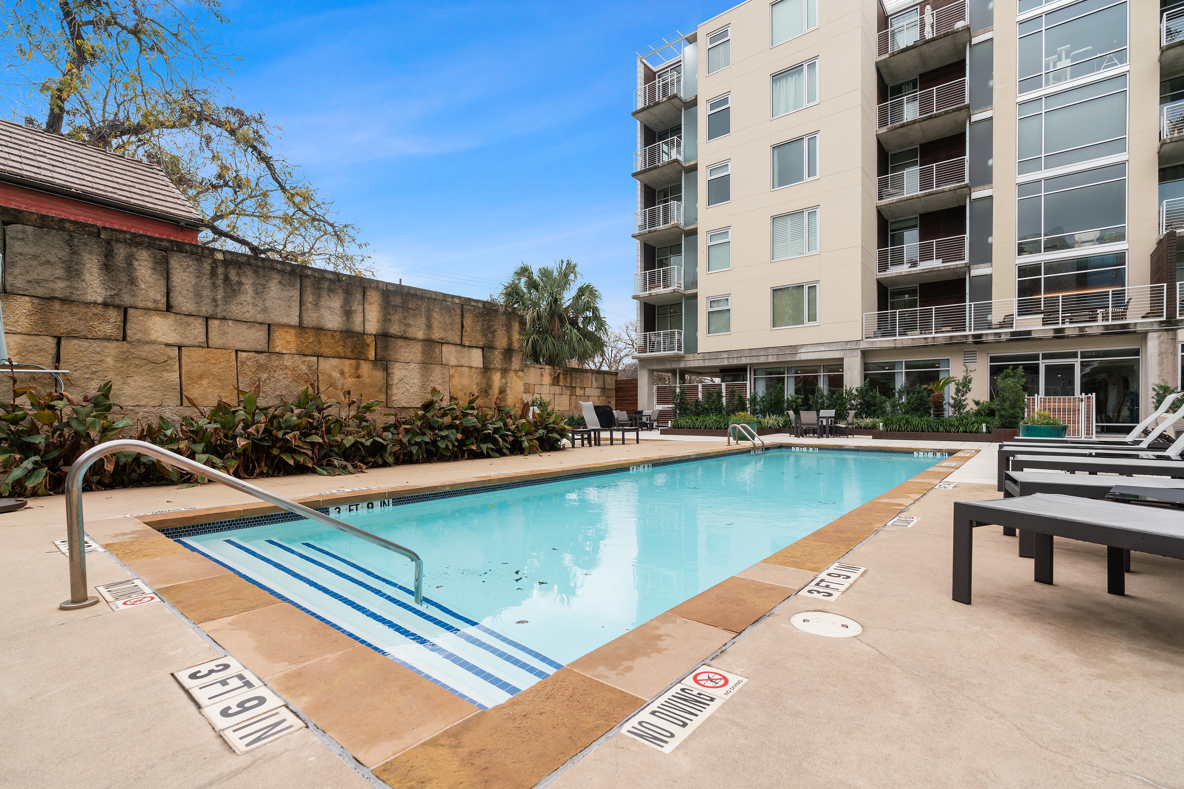 210 Lee Barton Drive, Unit 517 Austin, TX 78704 - Photo 31 of 32 a view of a swimming pool with a lounge chairs