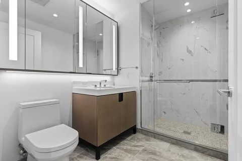 a bathroom with a sink a toilet and shower