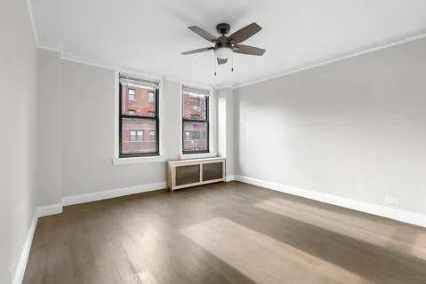 an empty room with windows and ceiling fan