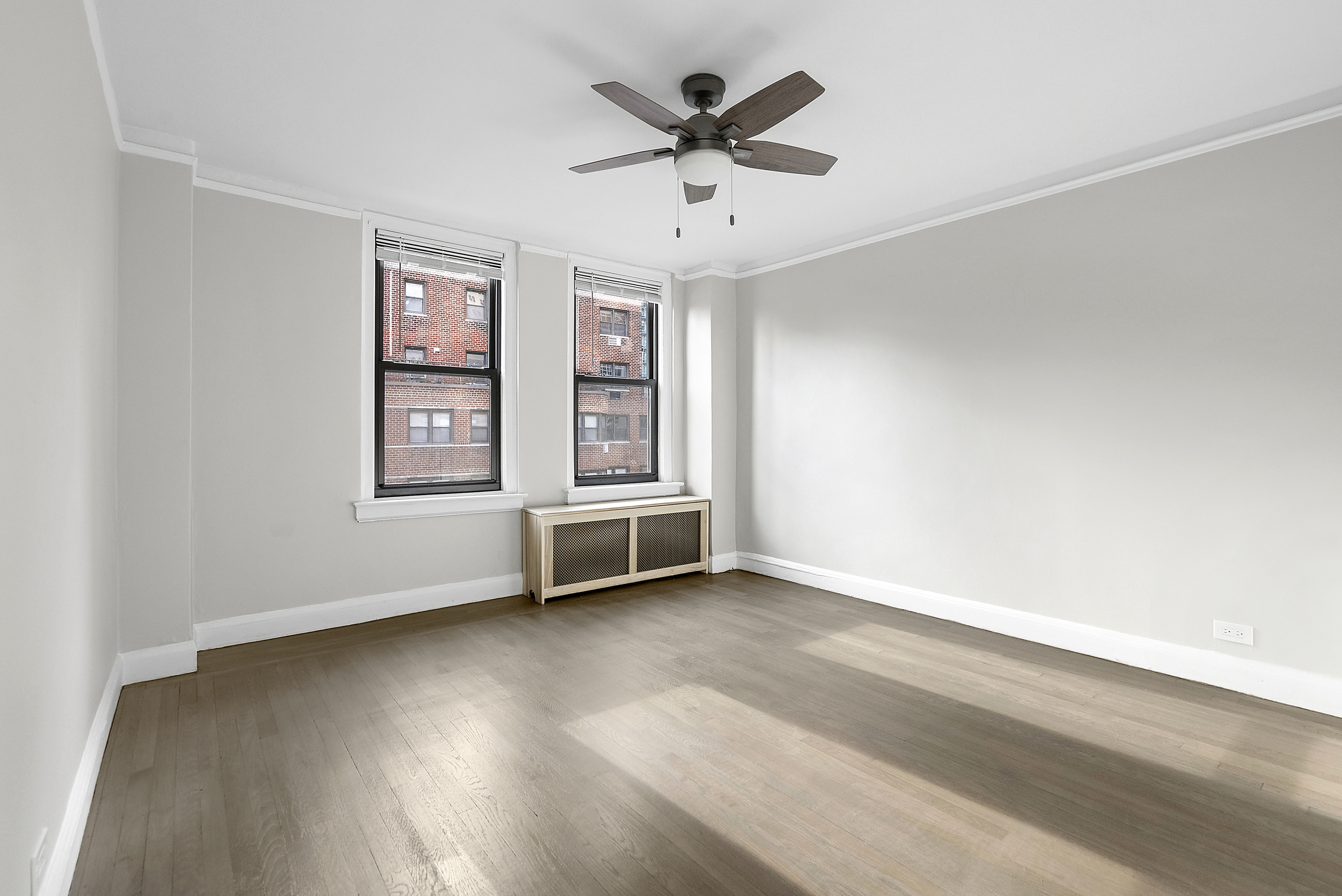 321 East 54th Street, Unit 10B Manhattan, NY 10022 - Photo 7 of 13 an empty room with windows and ceiling fan