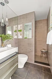 a bathroom with a sink a toilet a mirror and window