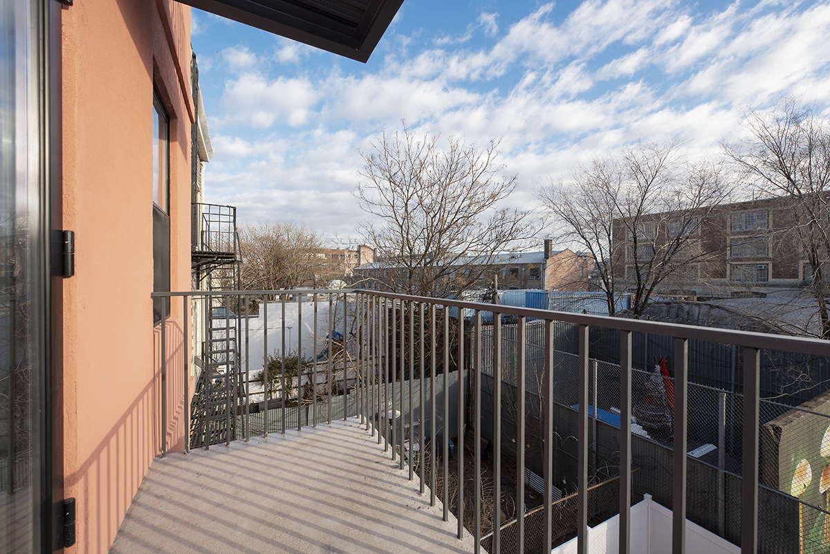 216 Boerum Street, Unit 3B Brooklyn, NY 11206 - Photo 6 of 10 a view of balcony with wooden floor and fence