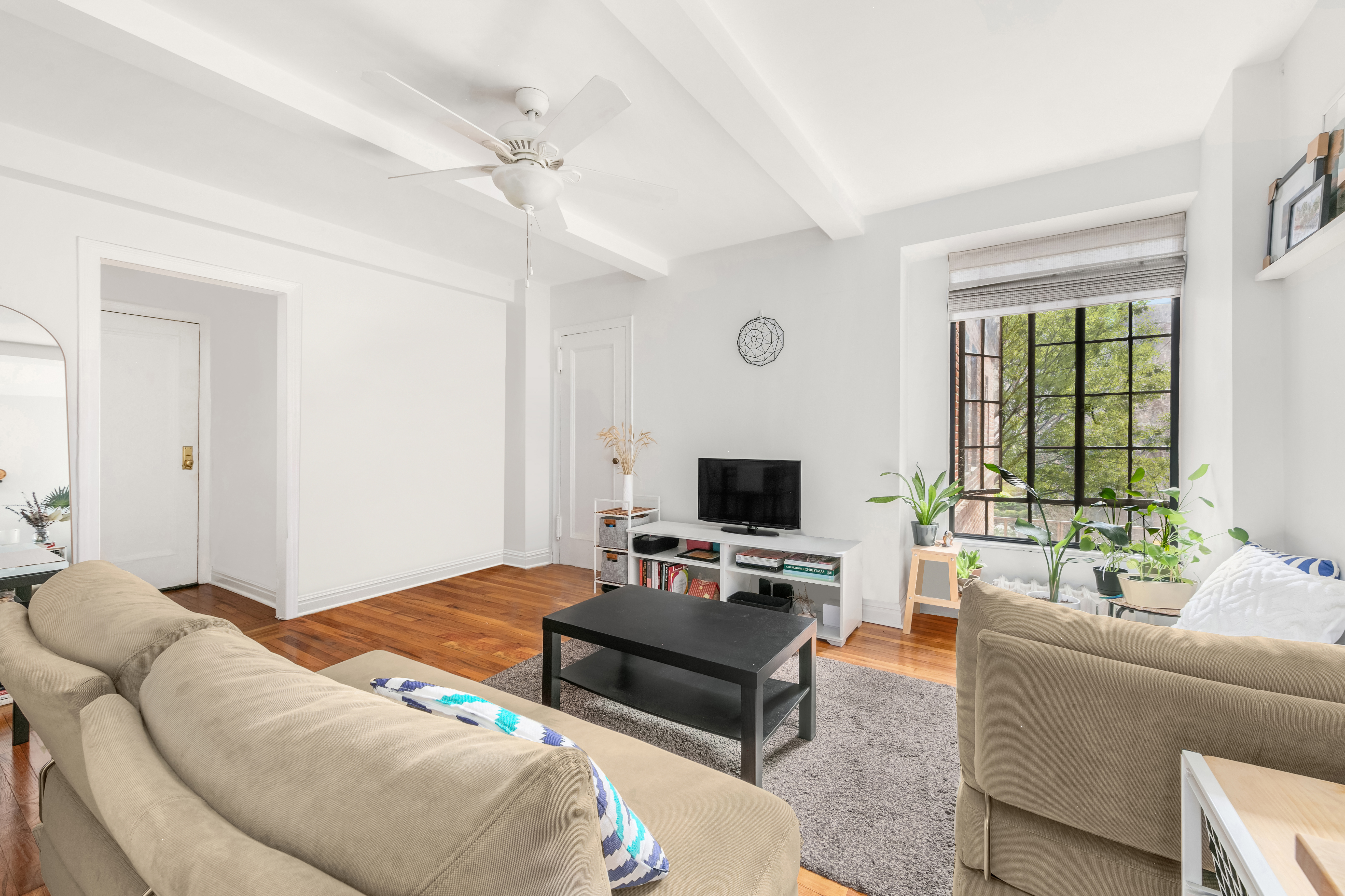 333 East 43rd Street, Unit 311 Manhattan, NY 10017 - Photo 1 of 18 a living room with furniture and a flat screen tv