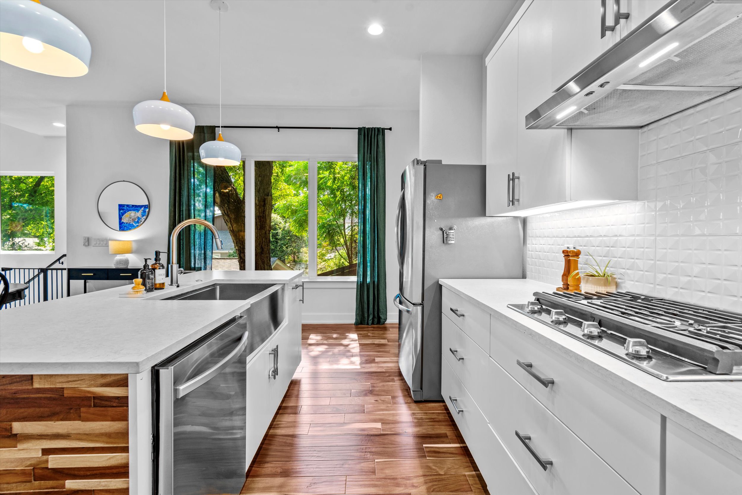 2712 Oak Springs Drive, Unit A Austin, TX 78702 - Photo 24 of 38 a kitchen with stainless steel appliances a stove a sink dishwasher and white cabinets with wooden floor