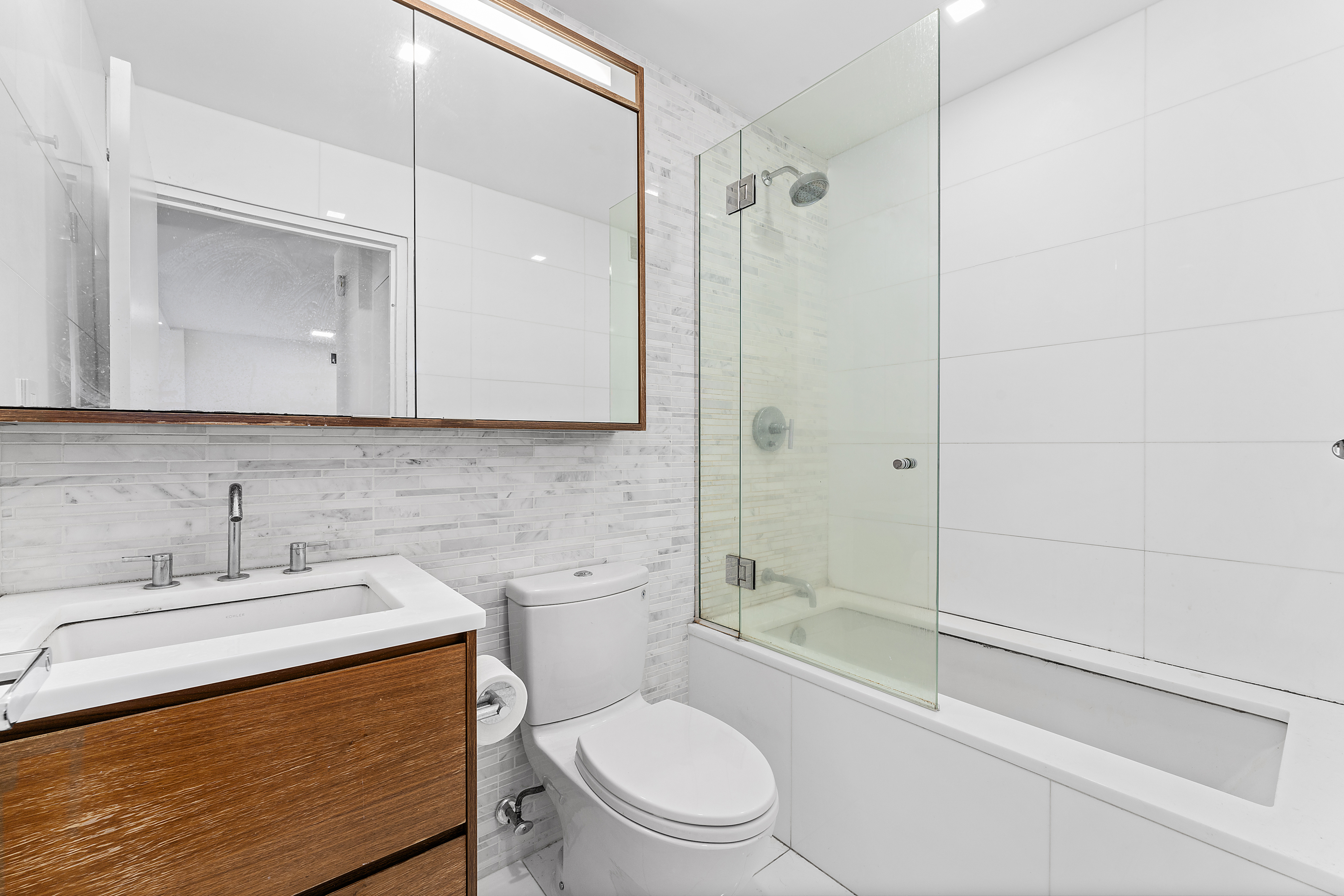 301 West 53rd Street, Unit 8J Manhattan, NY 10019 - Photo 7 of 14 a bathroom with a sink a toilet and shower