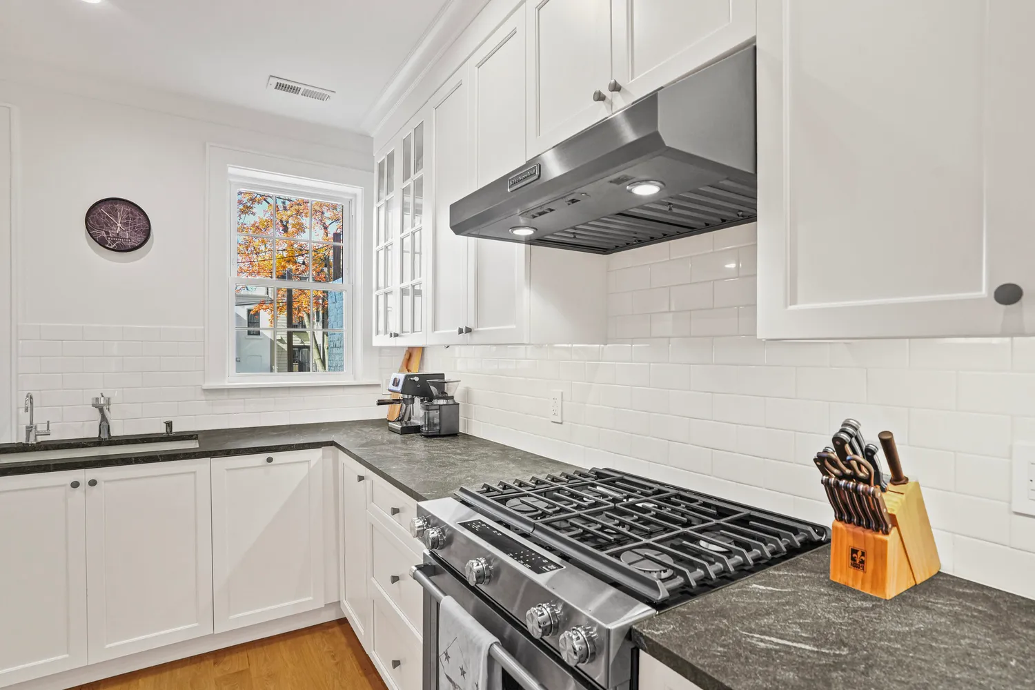 a kitchen with stainless steel appliances granite countertop a stove a sink and a microwave