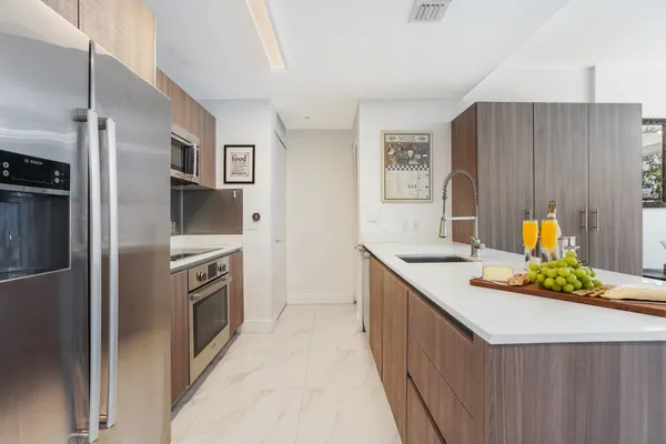 a kitchen with stainless steel appliances granite countertop a sink and a refrigerator