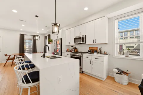 a kitchen that has a sink cabinets counter space and appliances