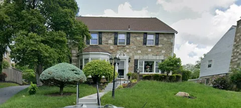 a front view of a house with a garden and plants