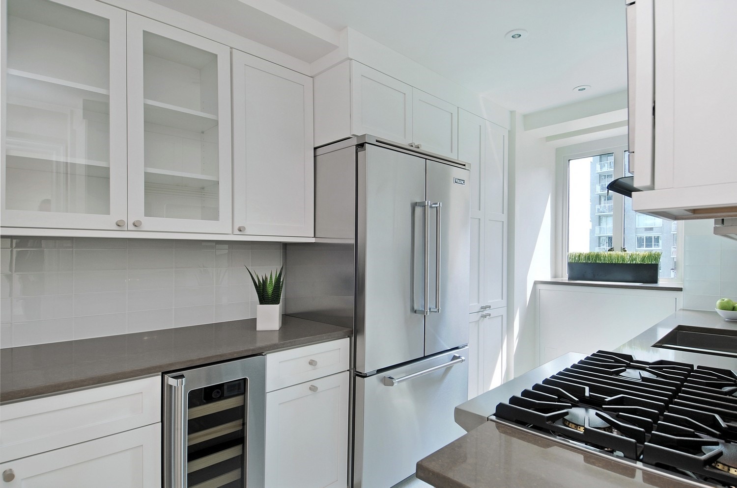 200 East 66th Street, Unit D804 Manhattan, NY 10065 - Photo 4 of 10 a kitchen with a refrigerator and a stove top oven