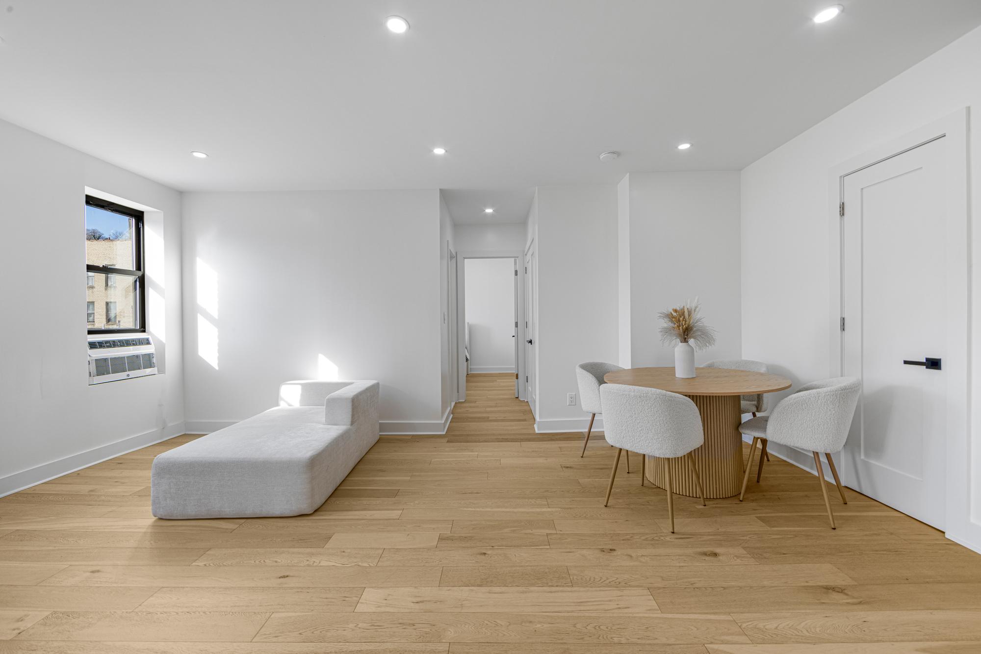 78 Thayer Street, Unit E5 Manhattan, NY 10040 - Photo 2 of 8 a living room with furniture and a wooden floor