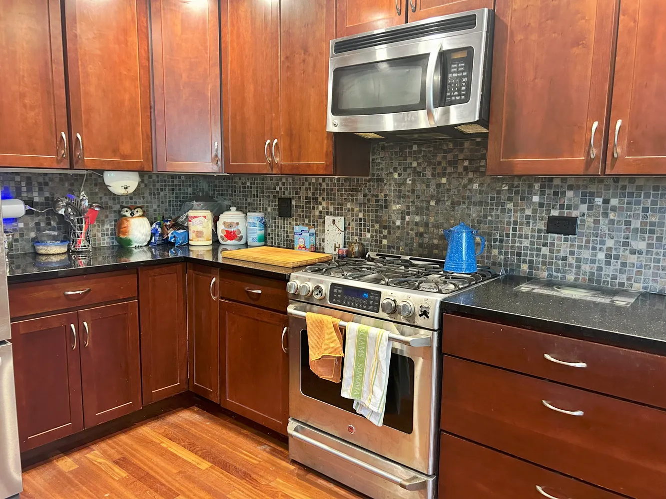 a kitchen with stainless steel appliances granite countertop wooden cabinets and a stove top oven