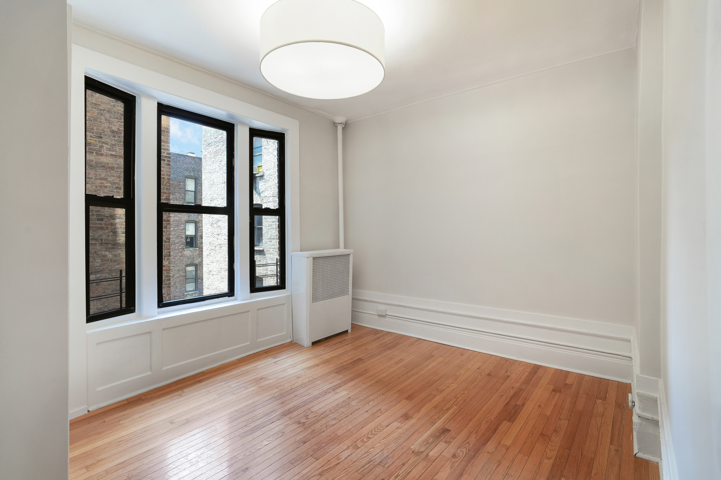 200 West 109th Street, Unit C1 Manhattan, NY 10025 - Photo 10 of 16 a view of an empty room with wooden floor and a window