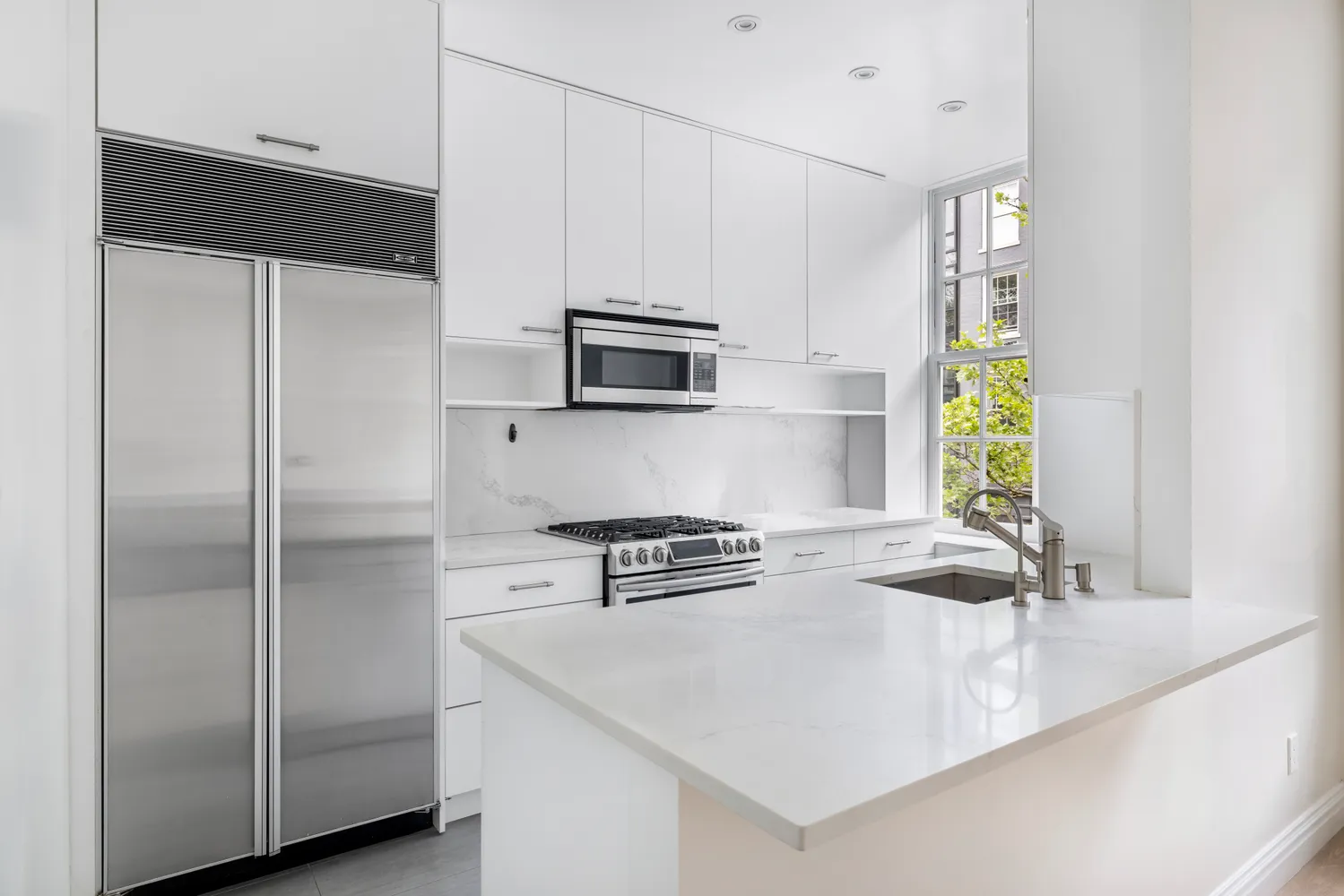 a kitchen with appliances a counter space and a window