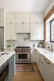 a kitchen with stainless steel appliances granite countertop a stove a sink and a white cabinets