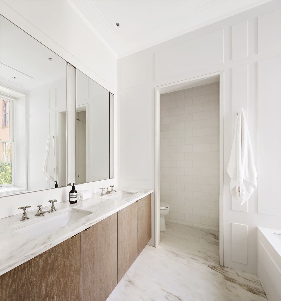 a bathroom with a double vanity sink mirror and bathtub