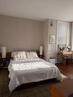 a bedroom with a bed a table and chair