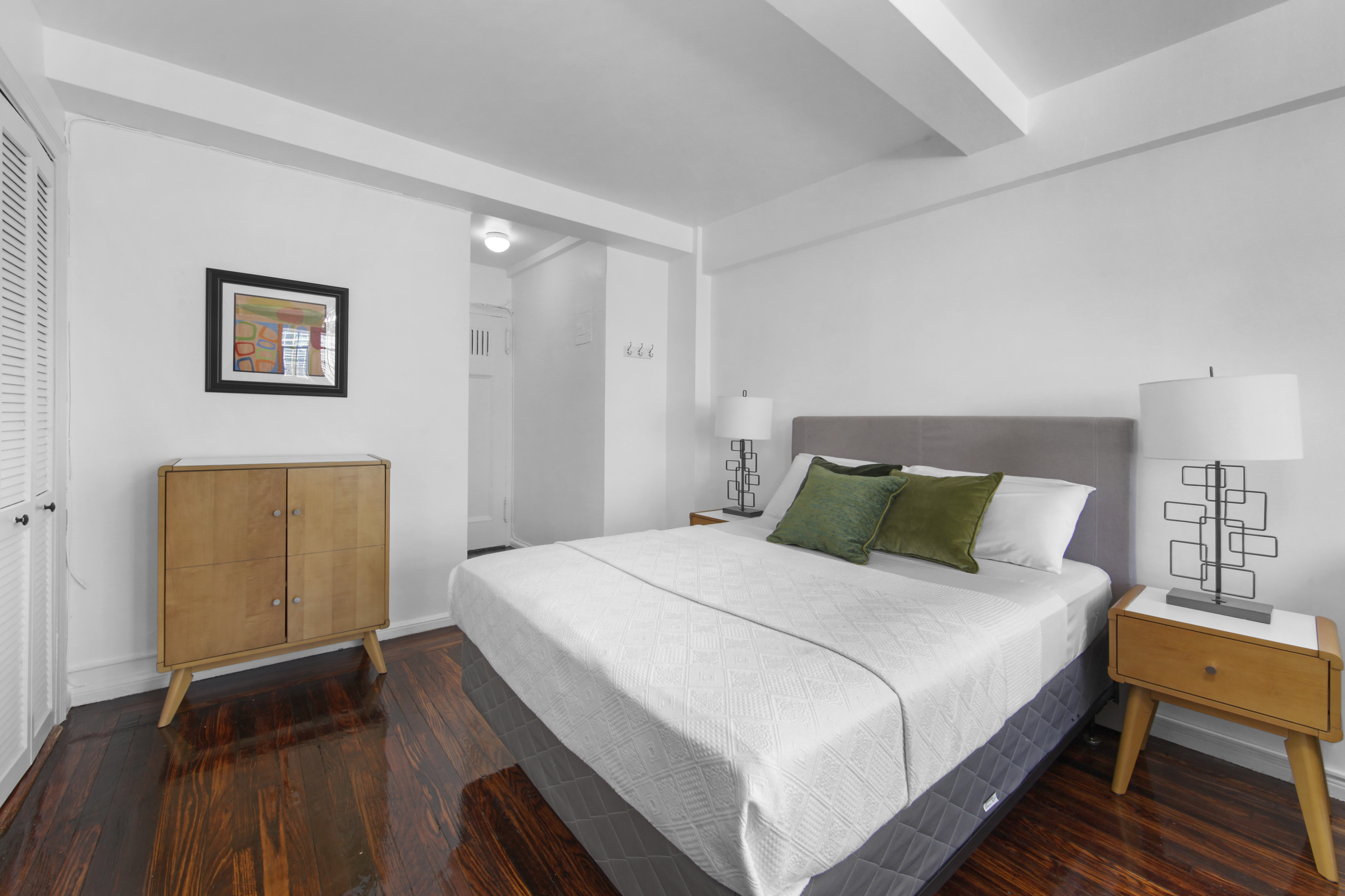 45 Tudor City Place, Unit 1902 Manhattan, NY 10017 - Photo 8 of 14 a bedroom with bed and wooden floor