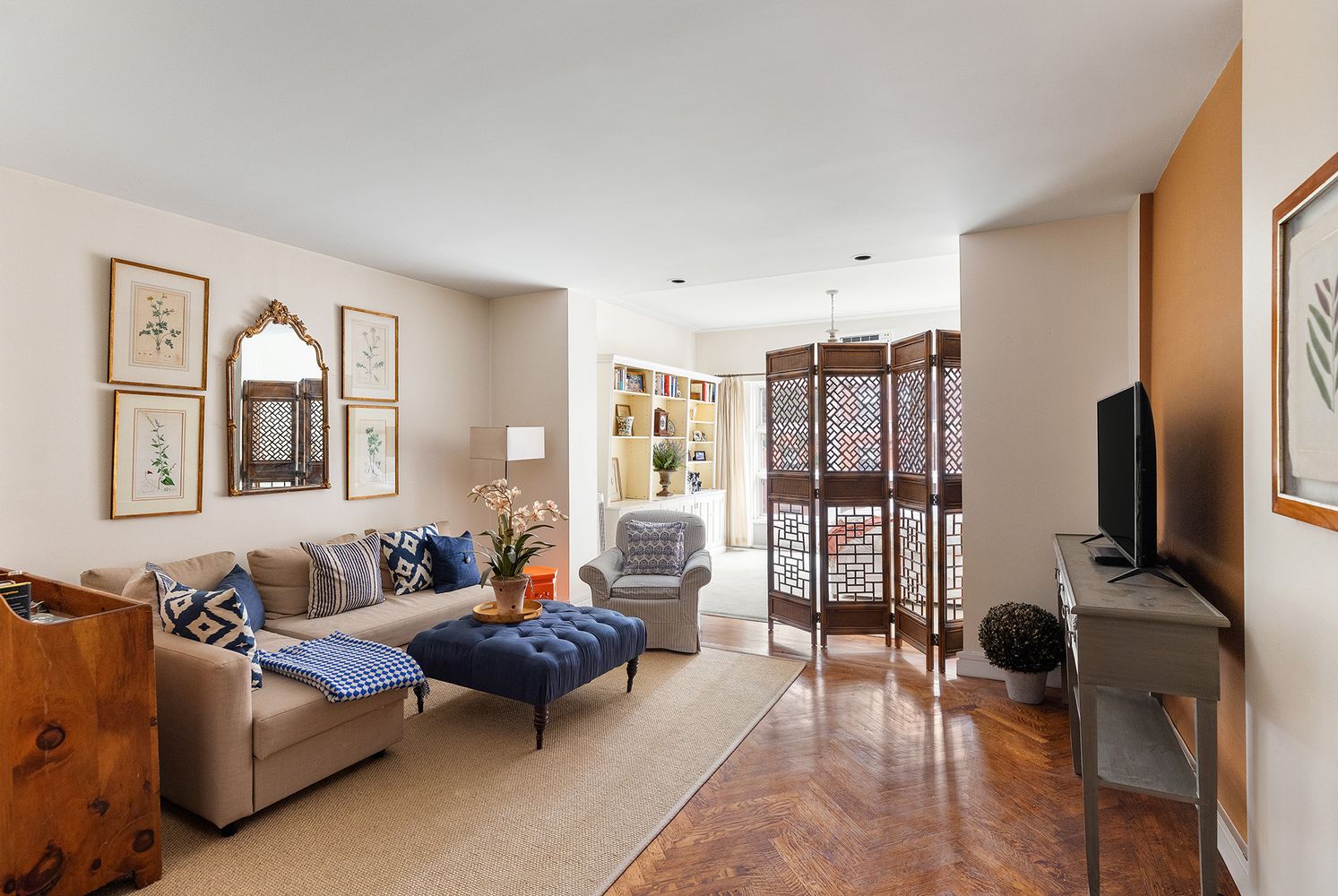 60 East 79th Street, Unit 3B Manhattan, NY 10075 - Photo 1 of 8 a living room with furniture a flat screen tv and a floor to ceiling window