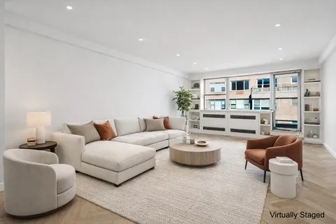 a living room with furniture and a book shelf