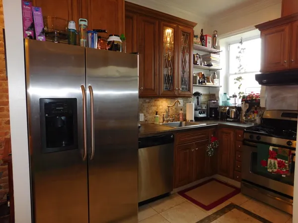 a kitchen with stainless steel appliances granite countertop a refrigerator and a stove top oven