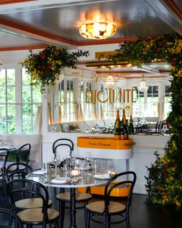 a dining room filled with lots of furniture and a chandelier