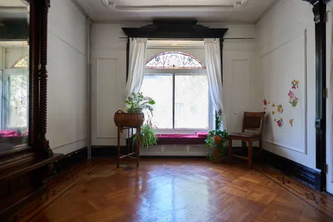 a living room with a bed and a large window