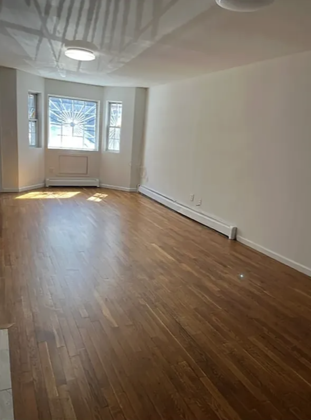 14 East 29th Street Brooklyn, NY 11226 - Photo 3 of 6 an empty room with wooden floor and windows