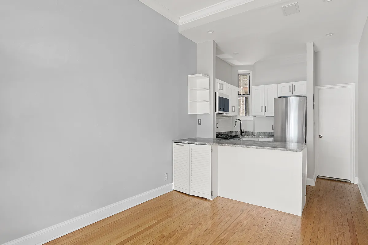 521 East 81st Street, Unit B Manhattan, NY 10028 - Photo 3 of 5 a kitchen with a refrigerator and white cabinets