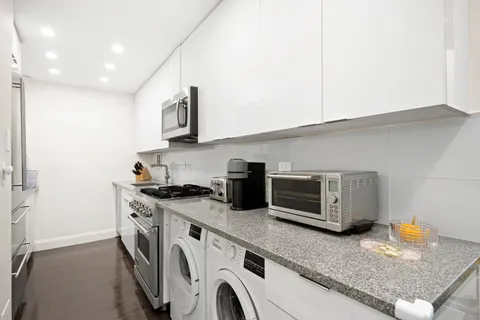 a kitchen with stainless steel appliances granite countertop a sink a stove and a microwave