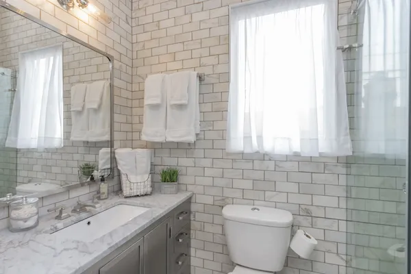 a bathroom with a toilet sink and mirror