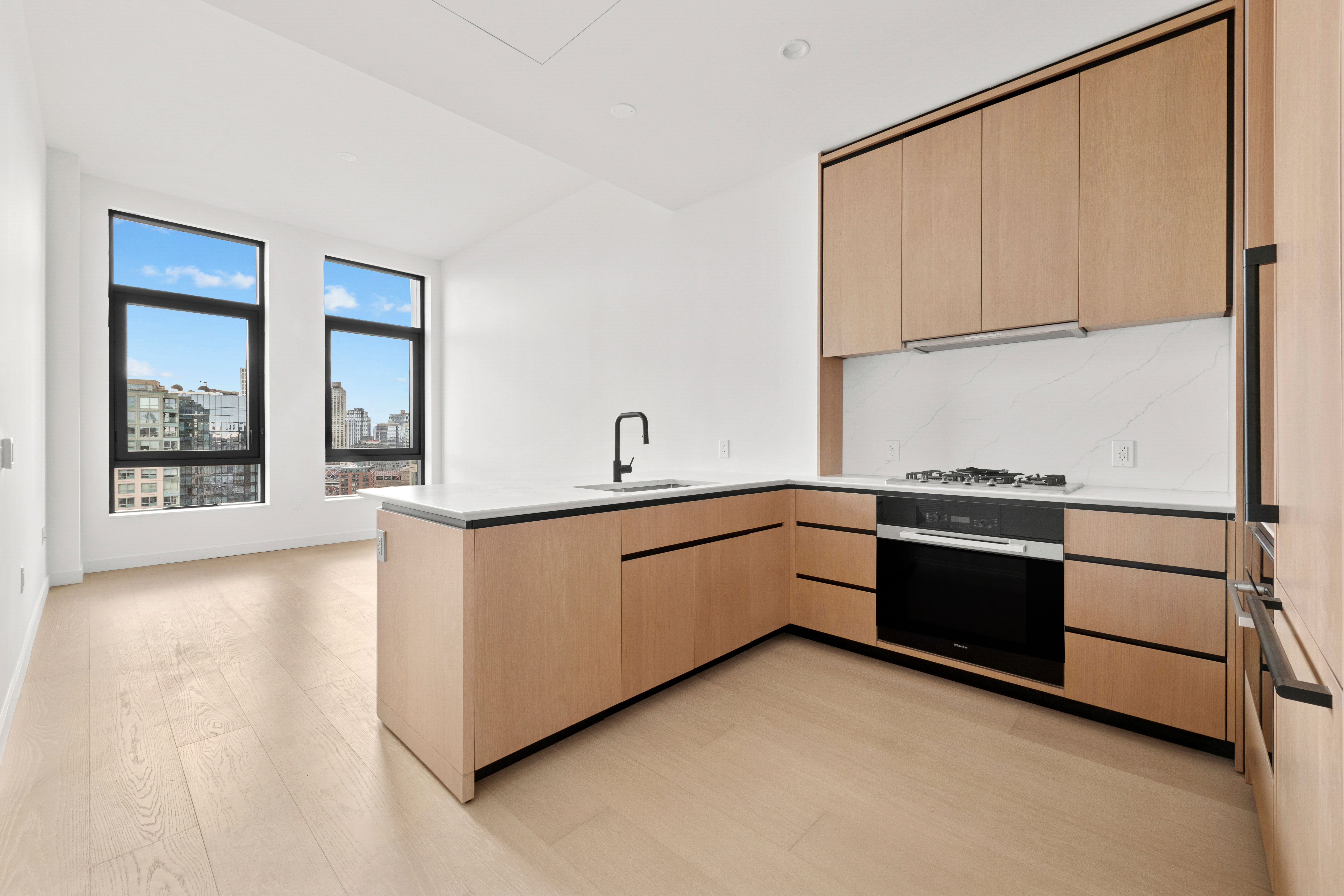 480 Kent Avenue, Unit 21C Brooklyn, NY 11249 - Photo 5 of 23 a kitchen with stainless steel appliances granite countertop a refrigerator sink and cabinets