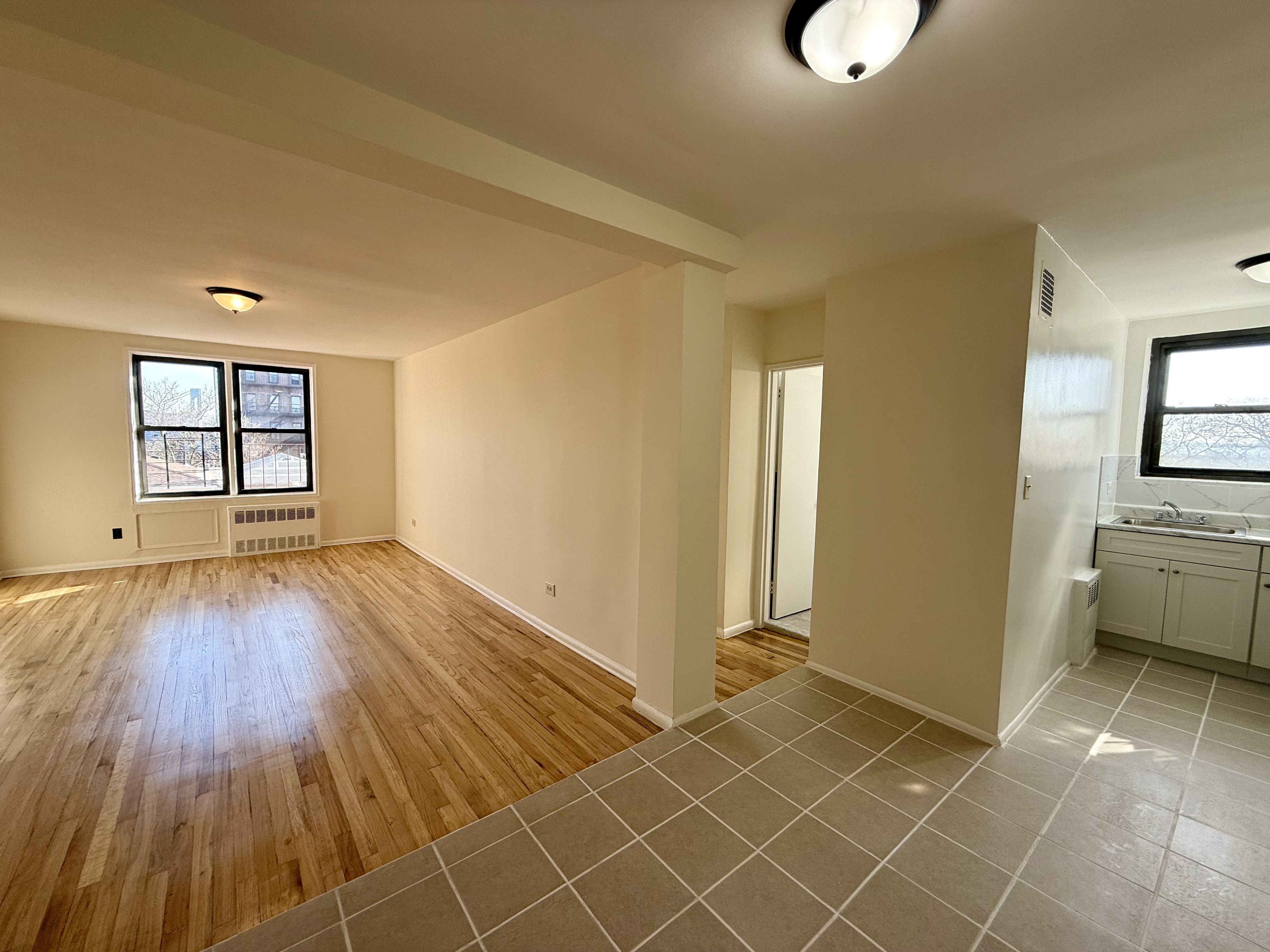230 73rd Street, Unit 4B Brooklyn, NY 11209 - Photo 3 of 9 an empty room with windows and wooden floor