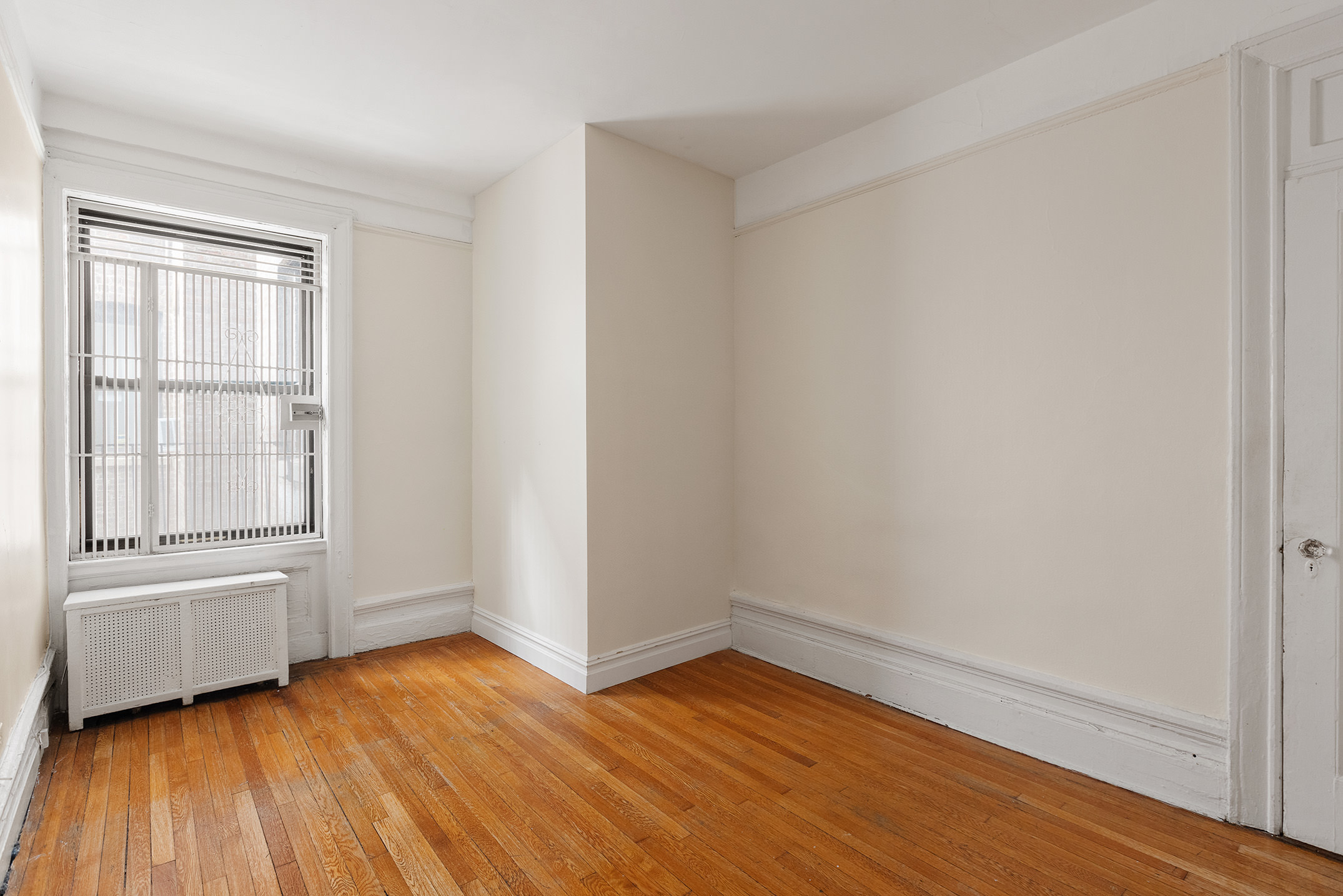 510 West 110th Street, Unit 2E Manhattan, NY 10025 - Photo 6 of 13 an empty room with wooden floor and windows