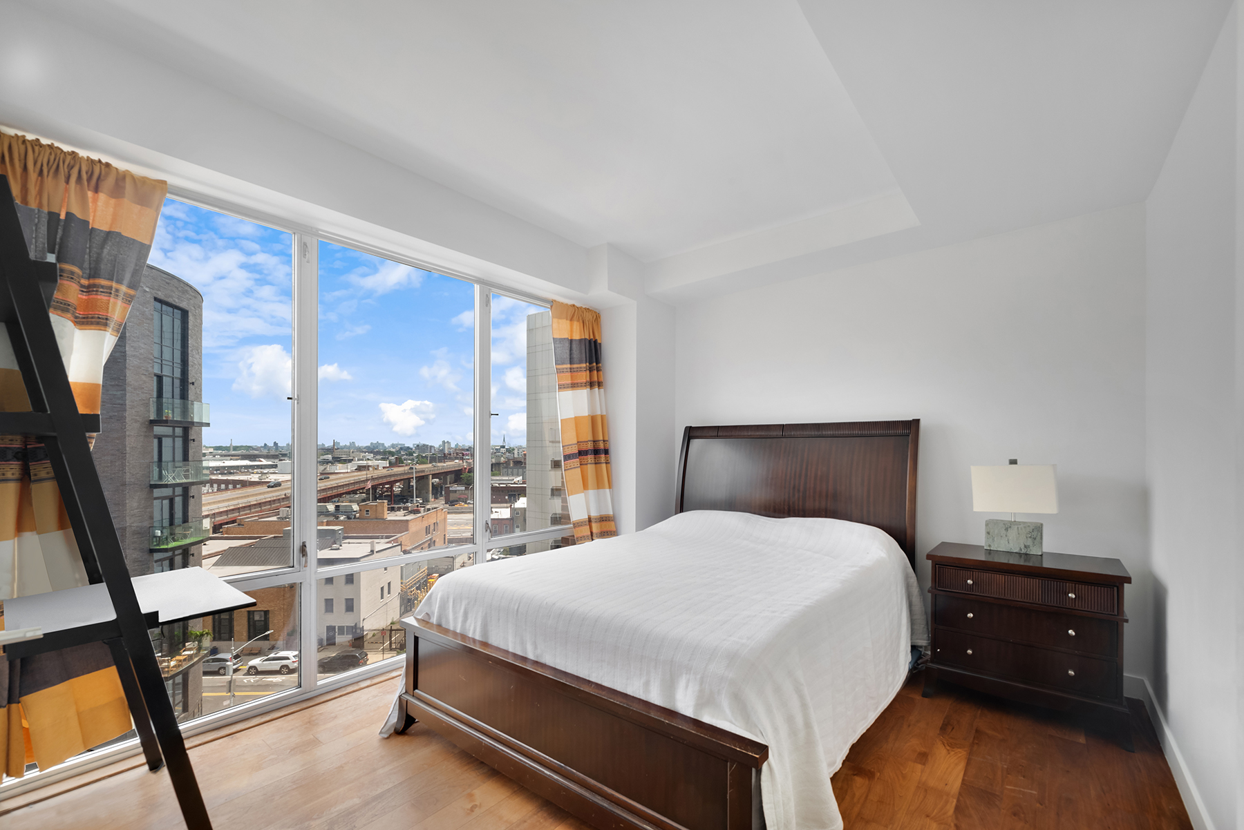 10-63 Jackson Avenue, Unit 7A Queens, NY 11101 - Photo 6 of 11 a bedroom with a bed and glass wall