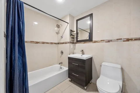 a bathroom with a toilet sink and mirror